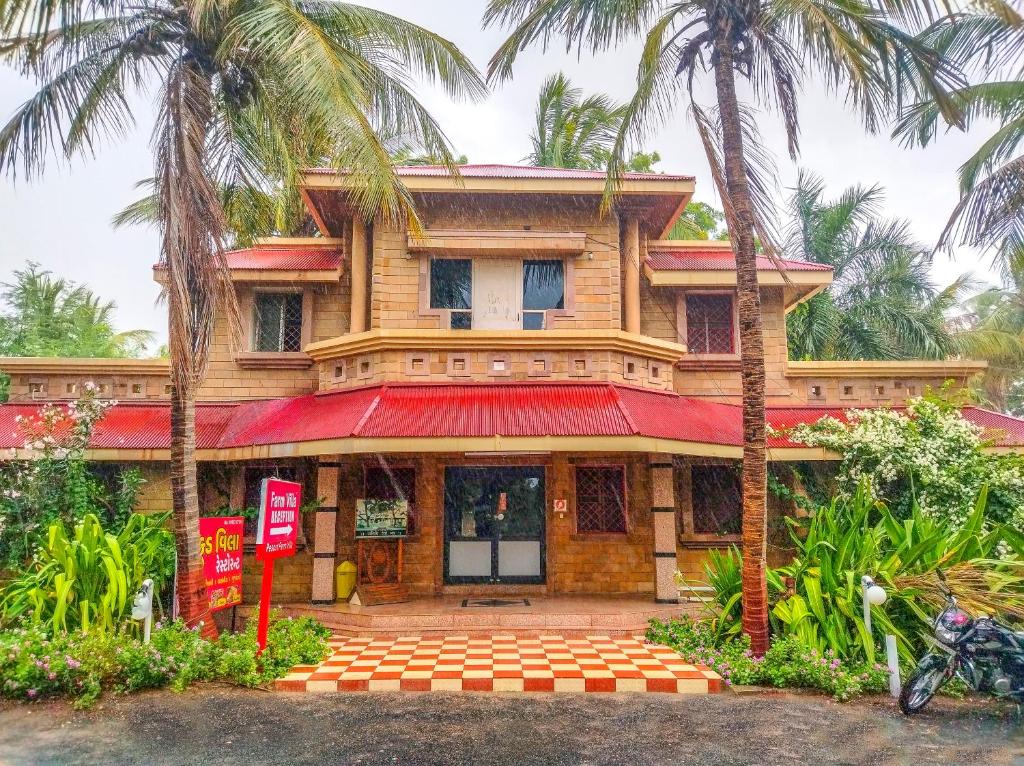 a house with palm trees in front of it at RESORT FARM VILLA in Bhuj