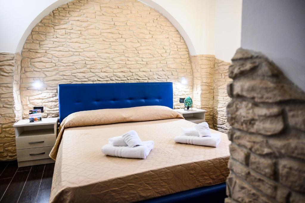a bedroom with a bed with two towels on it at Risa Apulia in Torre Lapillo