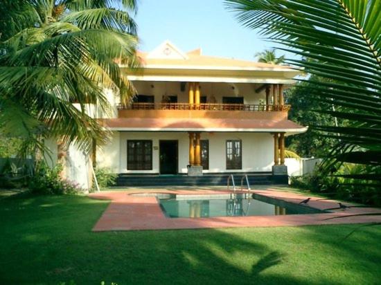 dom z basenem przed nim w obiekcie Fool's Paradise w mieście Alappuzha