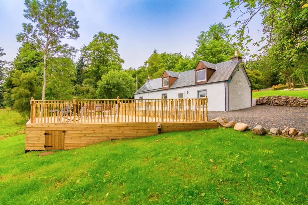 a wooden deck in front of a house at Cairngorms Cottage in Cray