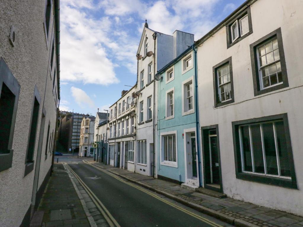 an empty city street with white and blue buildings at 5C Queen Street in Whitehaven