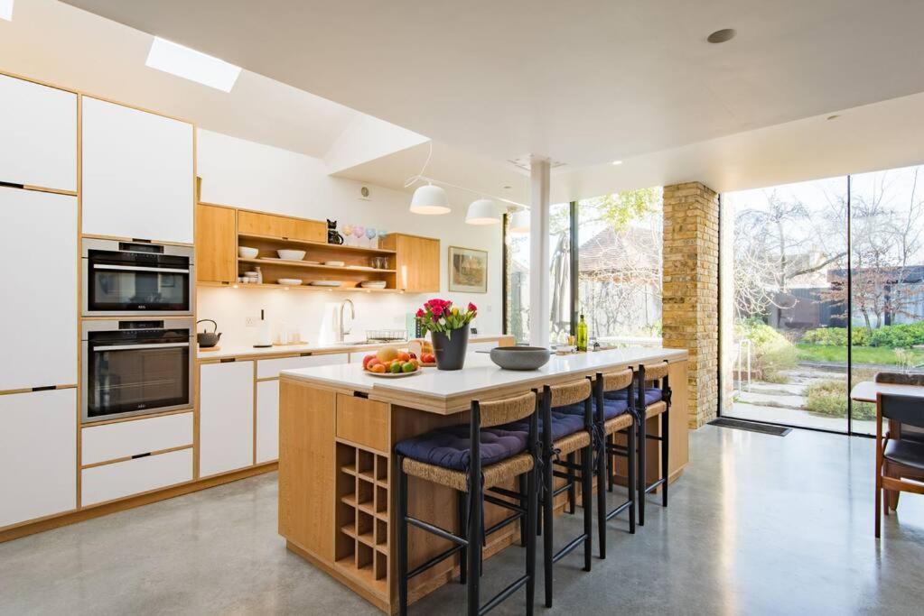 a kitchen with a large island with bar stools at The Modern Cottage in Whitstable