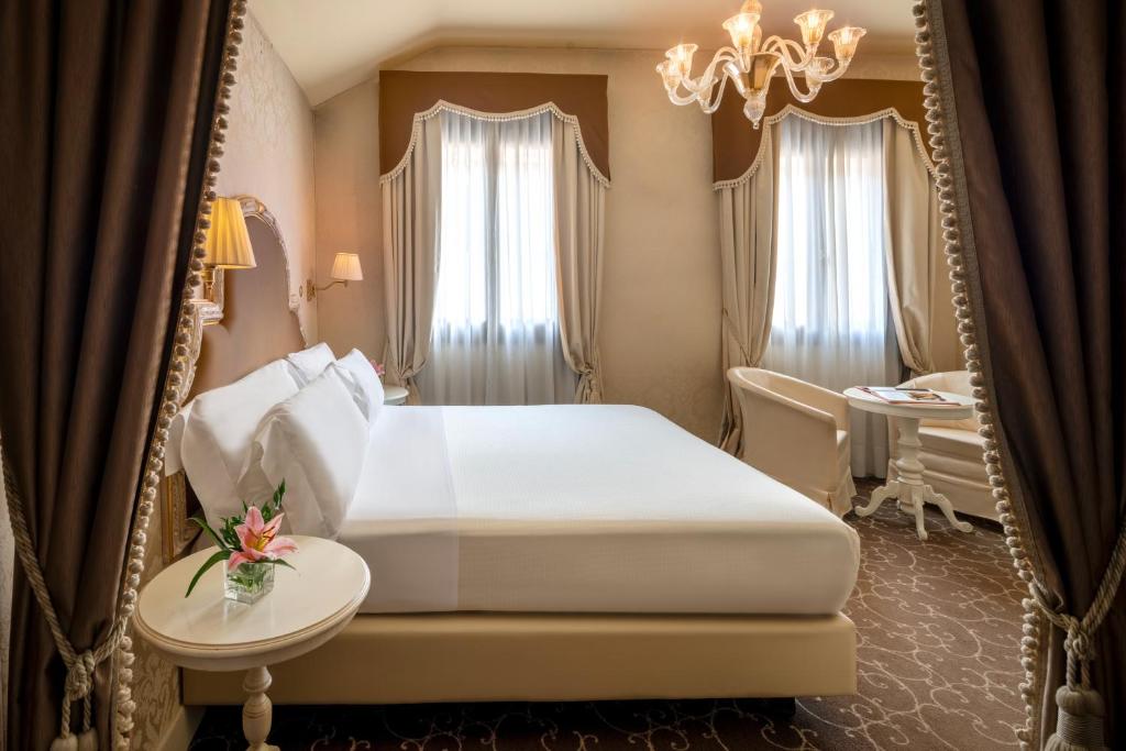a bedroom with a white bed and a mirror at Residenza Venezia | UNA Esperienze in Venice