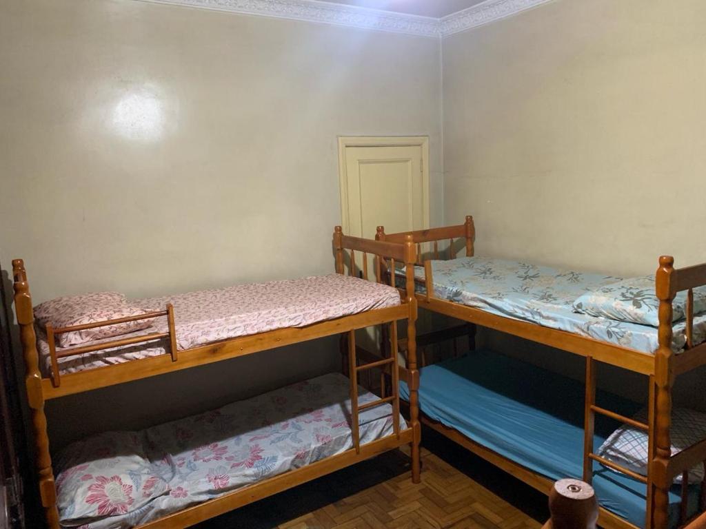 two bunk beds in a room with a door at I Love Rio Hostel in Rio de Janeiro