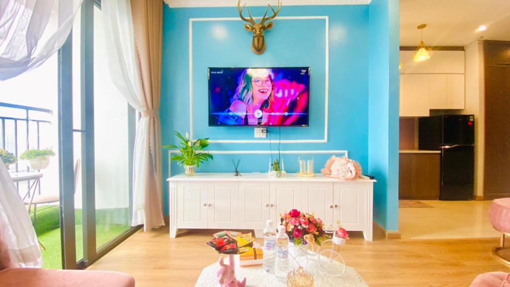 un salon avec une télévision sur un mur bleu dans l'établissement Studio Cao Cấp Hạ Long, à Hạ Long