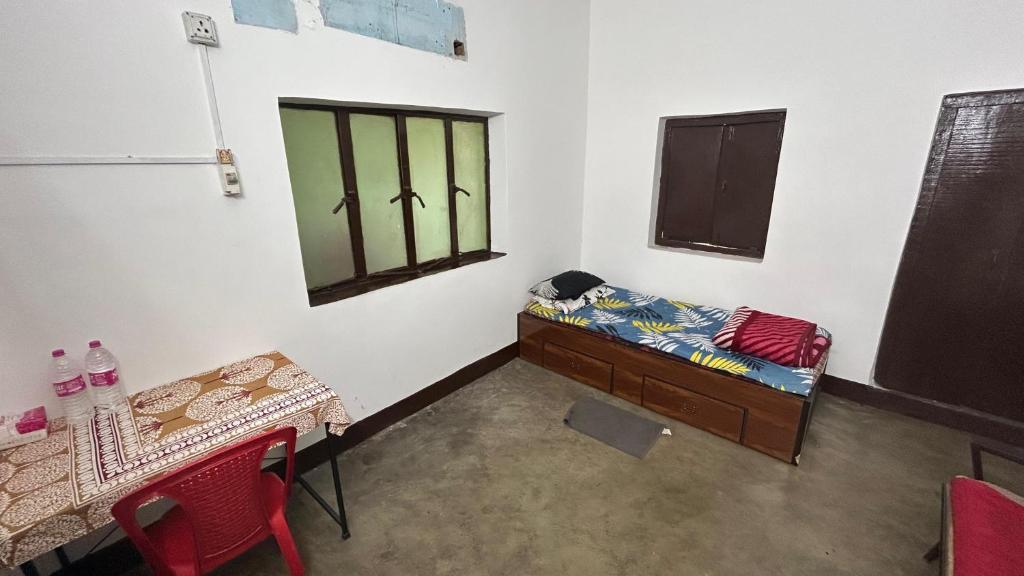 um quarto com uma cama, uma mesa e uma janela em Debnath Homes em Jamshedpur