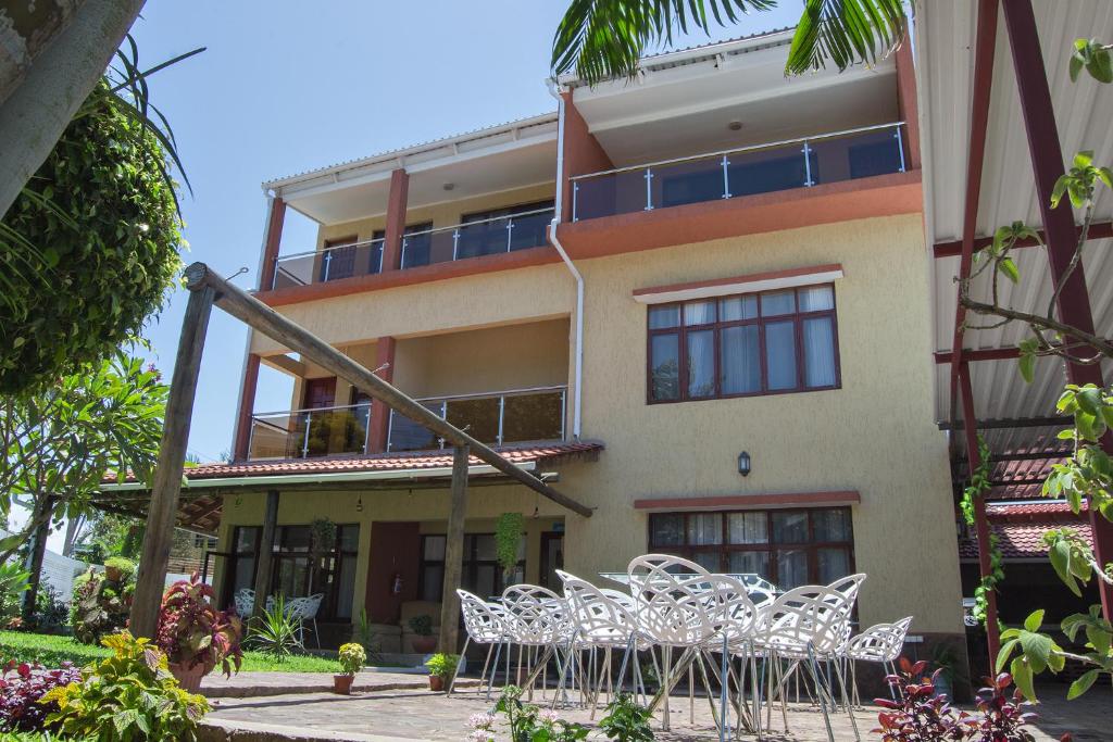 um edifício com cadeiras brancas em frente em Kutenga Guest House em Maputo
