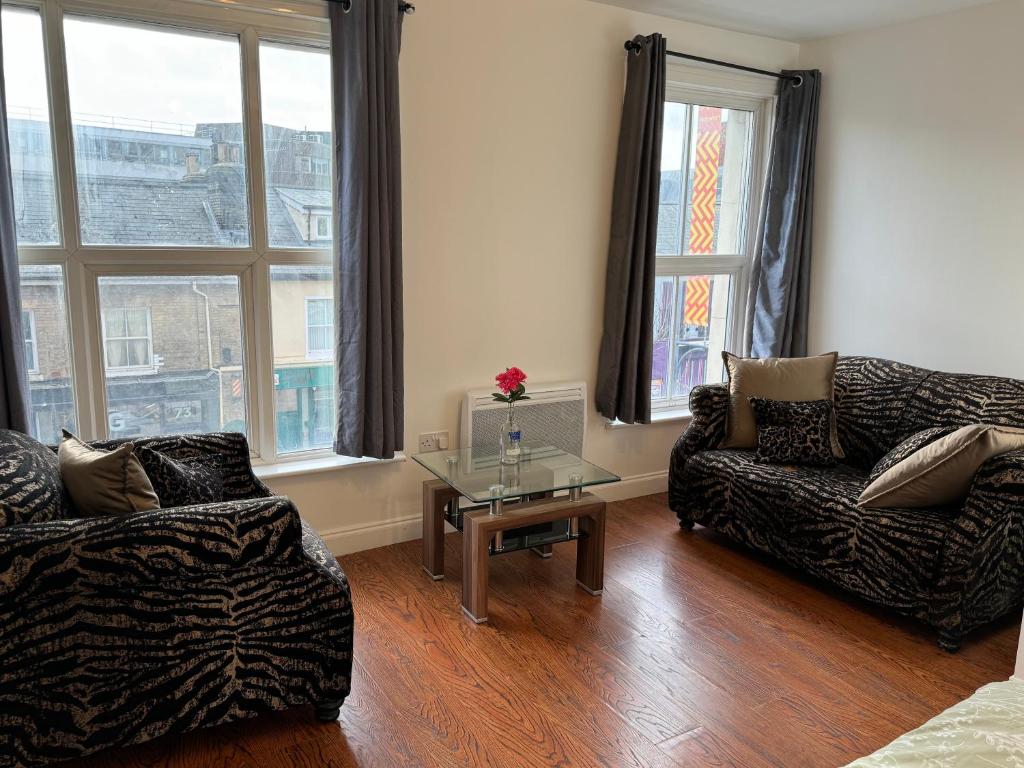 ein Wohnzimmer mit 2 Sofas und einem Tisch in der Unterkunft Prince Apartment Inn in Norwich