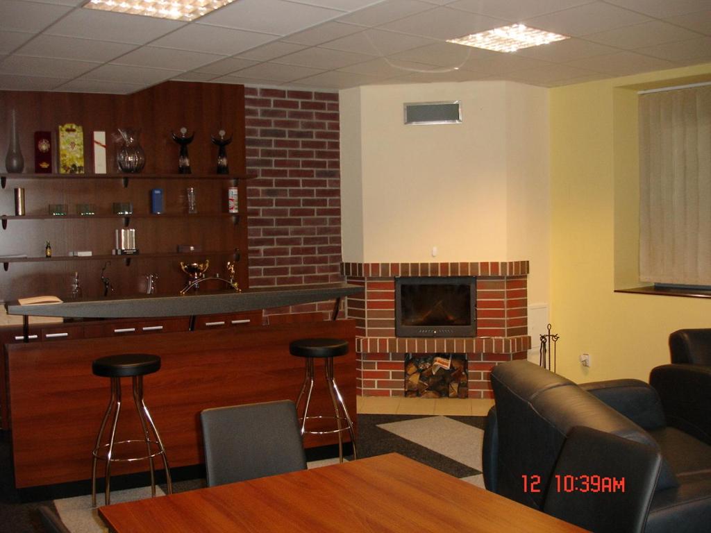 a living room with a fireplace and a table and chairs at Sporthotel Vestec in Vestec