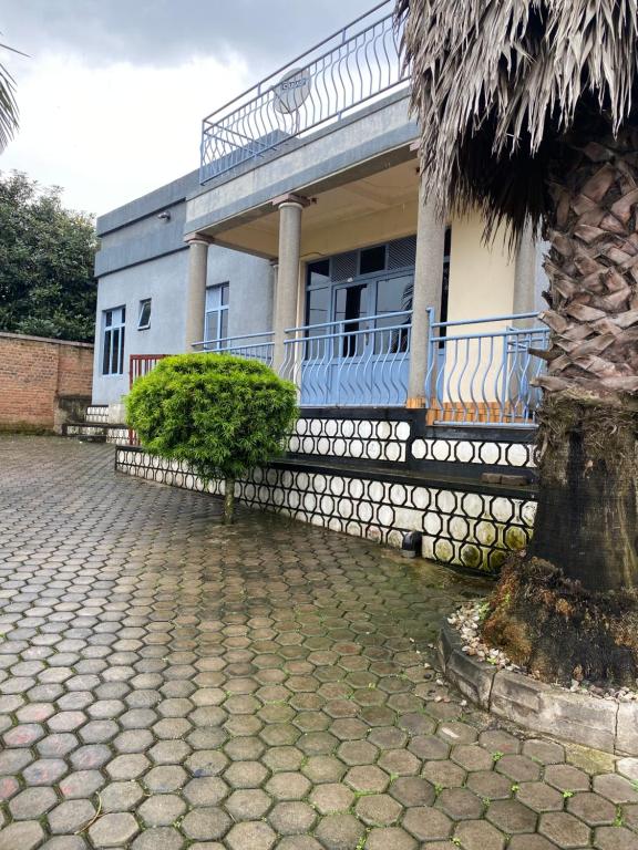 una casa con una palma di fronte di Golden motel a Gisenyi