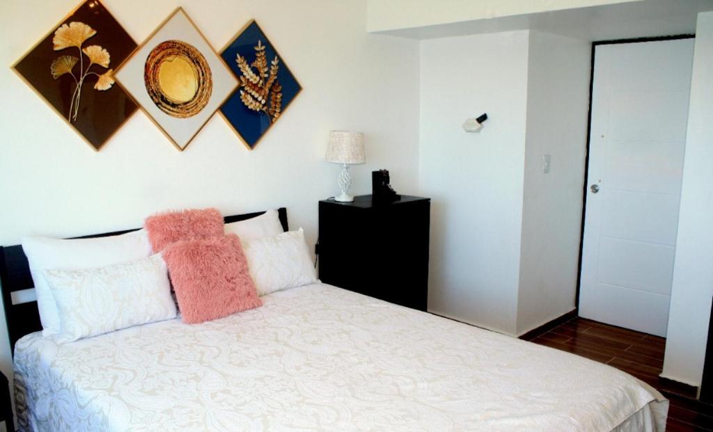 1 dormitorio con 1 cama blanca y 2 almohadas en Sturning Ocean View., en Santo Domingo