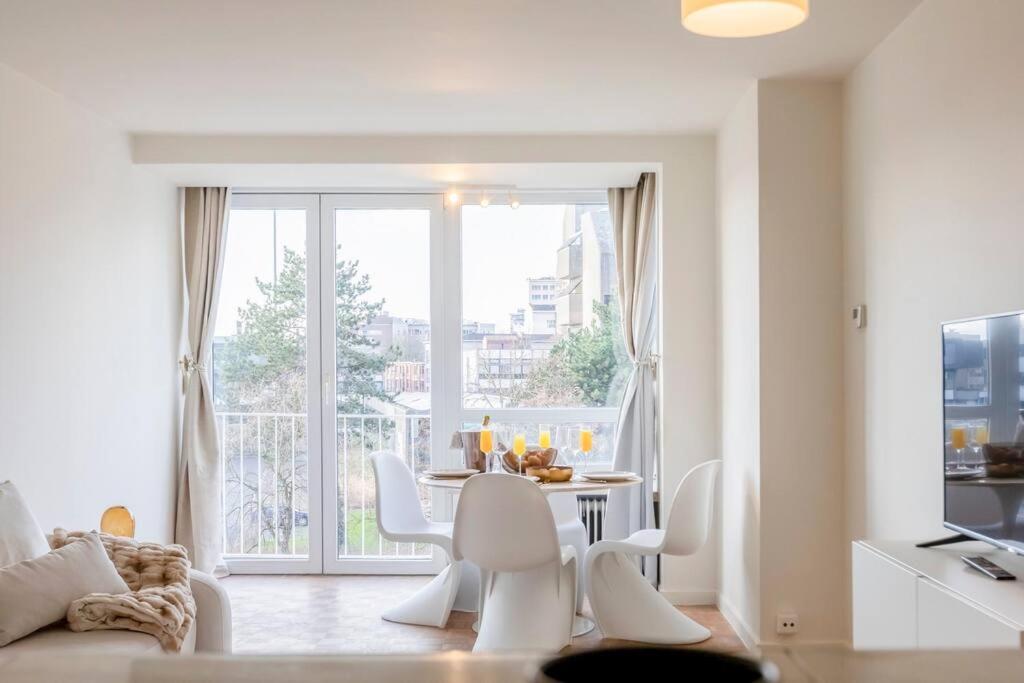 a white living room with a table and chairs at Luxury Leie View in Ghent