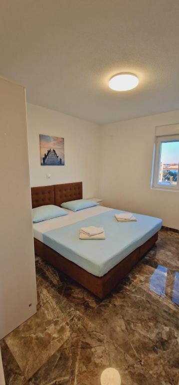 een slaapkamer met een groot bed in een kamer bij ANTODO Ivana in Novalja