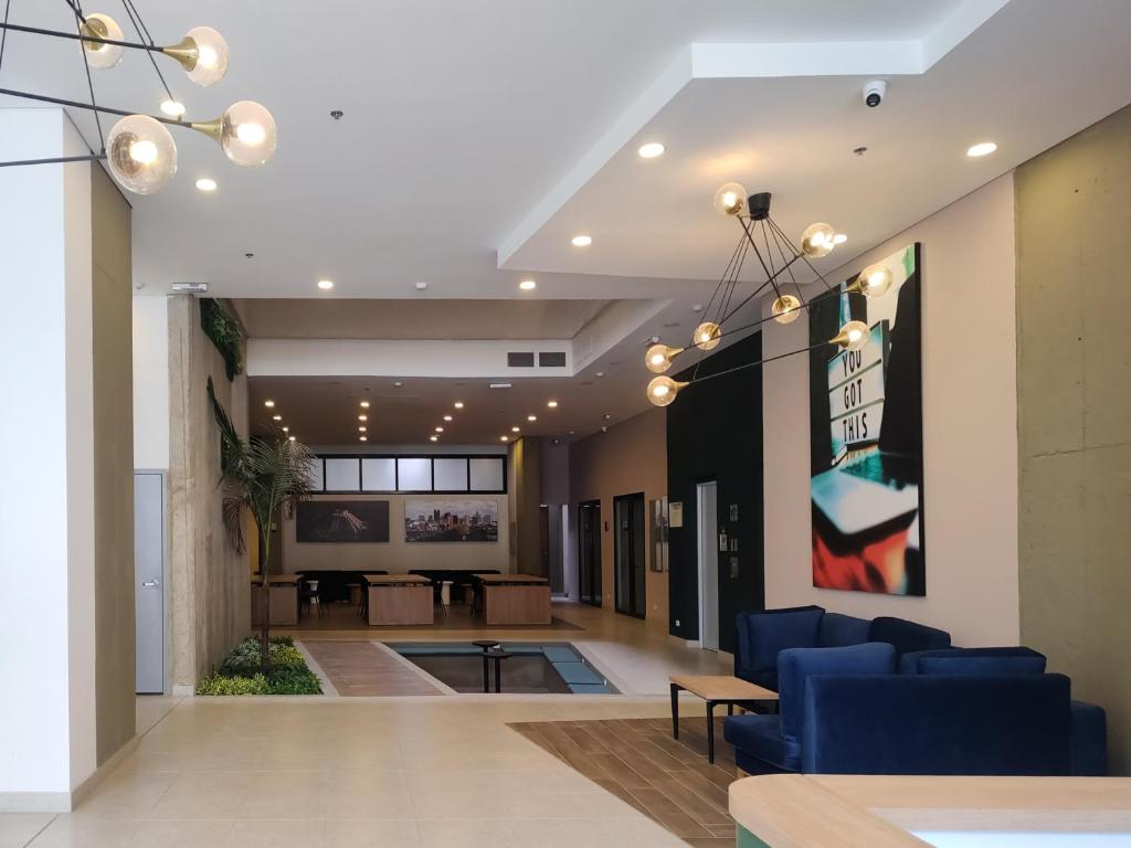 a lobby with blue chairs and a living room at The Hood 102, Modern and Luxury Apartments in Bogotá