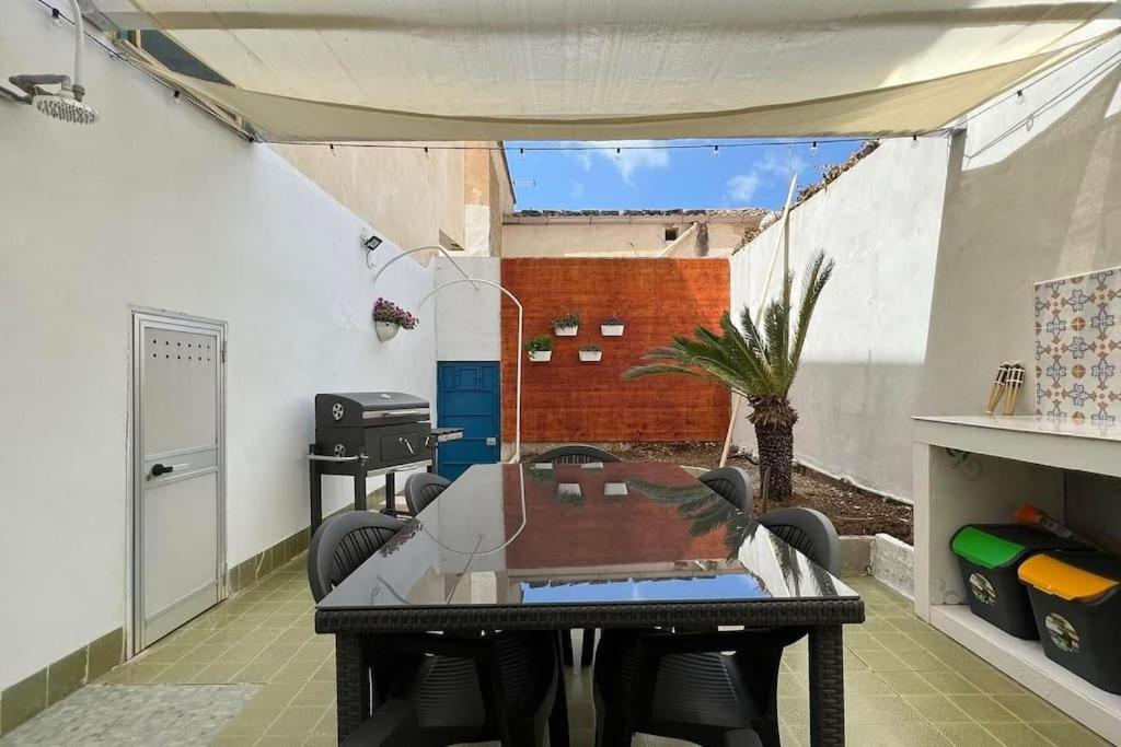 uma mesa e cadeiras num quarto com um pátio em Villa indipendente sul mare - Maiolica home&welfare em Alcamo Marina