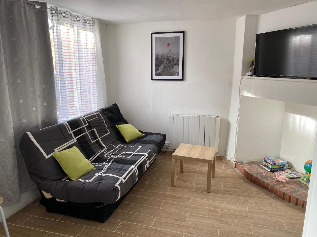 un salon avec un canapé et une table dans l'établissement Maison de ville, à La Cressonnière