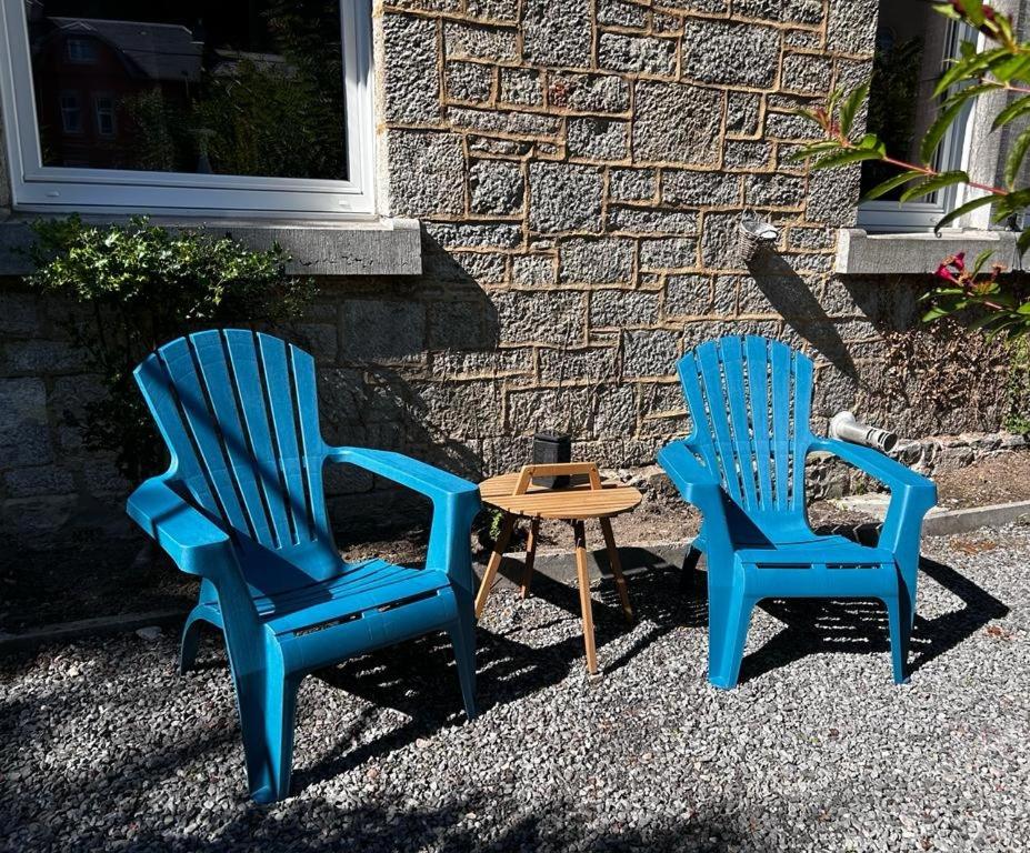 two blue chairs and a table in front of a building at Monsieur Michel in Dinant