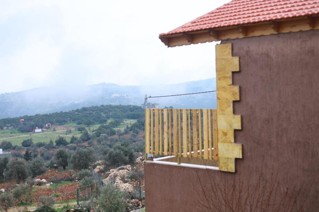 a balcony of a building with a view of a mountain at Rosemary Huts in Ajloun