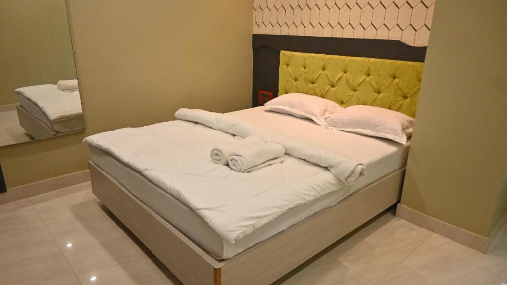 a bed with towels on it in a bedroom at Hotel Maisha International in Sonāmura