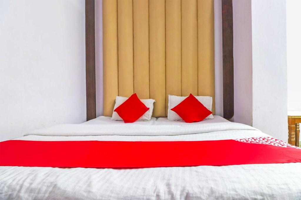 - un lit avec 2 oreillers rouges dans l'établissement Flagship Hotel Prem Chunaria, à Moradabad