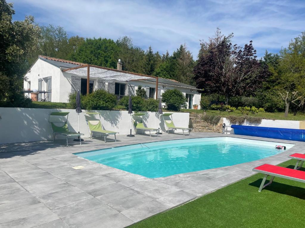 a swimming pool with chairs and a house at Borie Grande in Saint-Denis