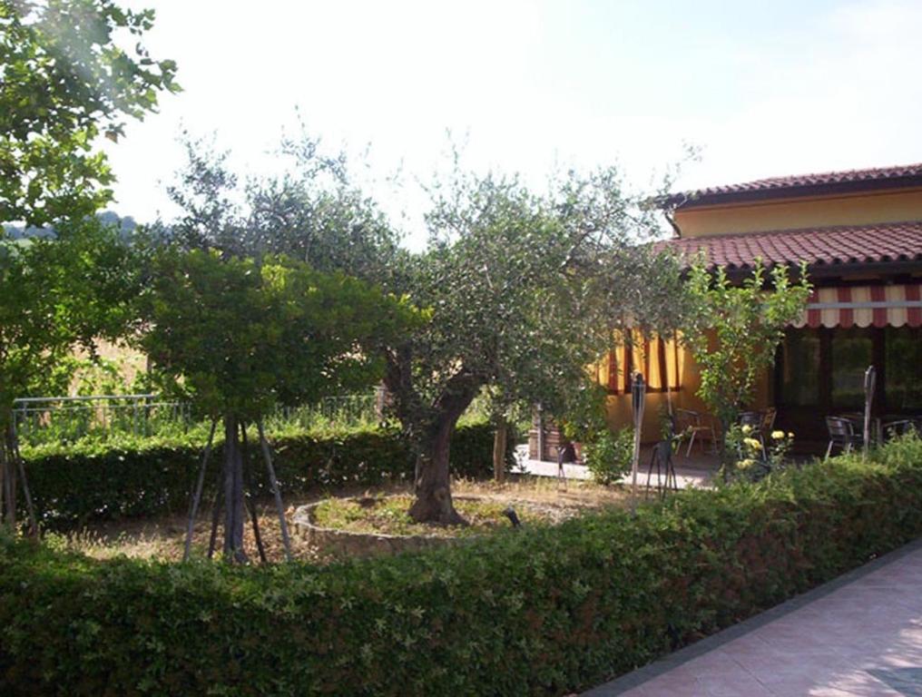 uma casa com um quintal com árvores e uma cerca em Agriturismo 7 Colonne em Bertinoro