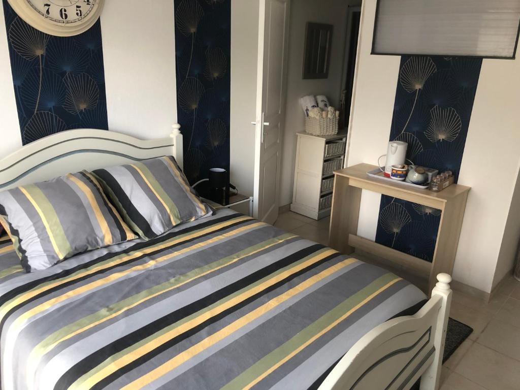 um quarto com uma cama e um relógio na parede em Chambre d hôte à la plage LE MANAPANY em Camiers