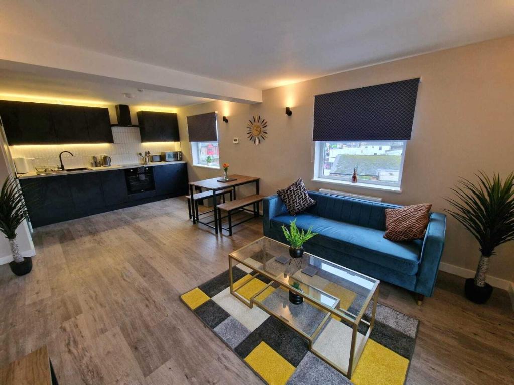 Il comprend un salon avec un canapé bleu et une cuisine. dans l'établissement Vere Apartments, à Cardiff