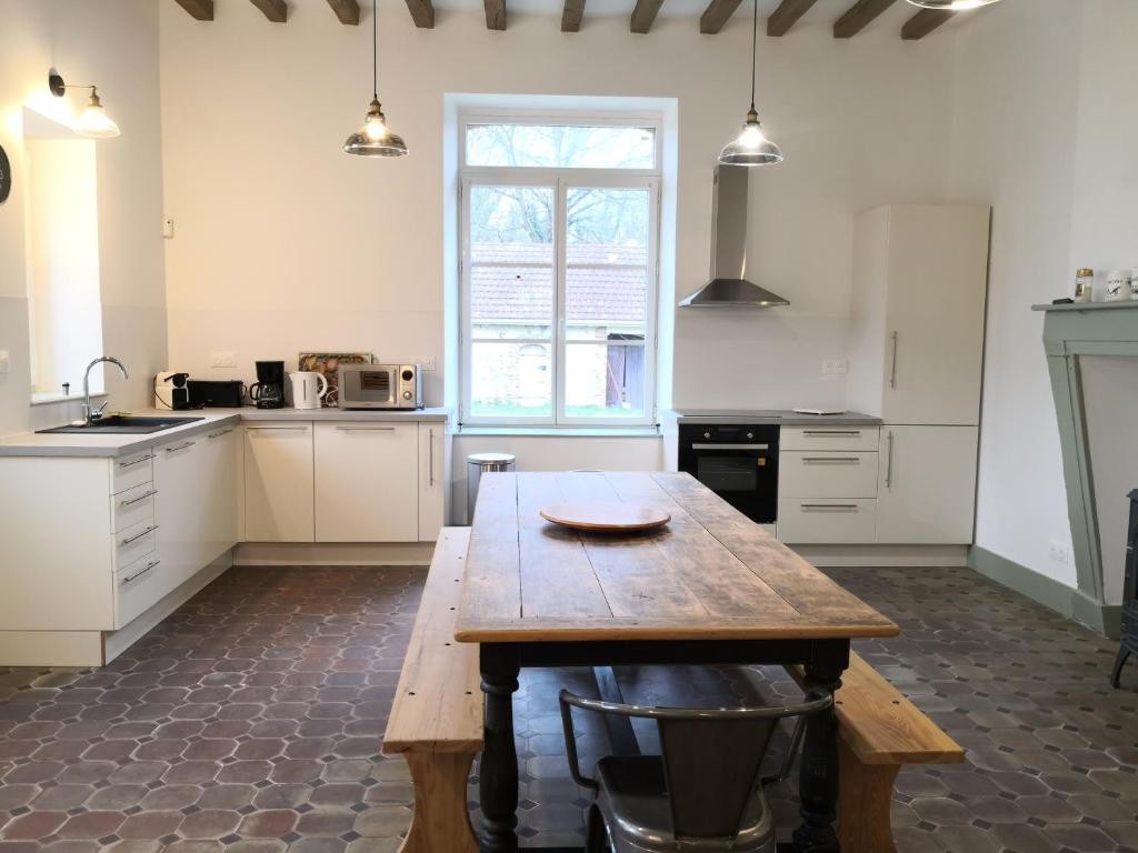 una gran cocina con una mesa de madera. en Domaine de l'Ile, en Boulleret