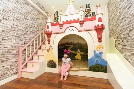 a little girl sitting in a room with a castle at Xin Yuan My Dream Castle in Dongshan