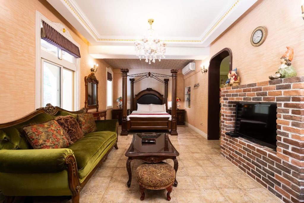 a living room with a green couch and a fireplace at Xin Yuan My Dream Castle in Dongshan