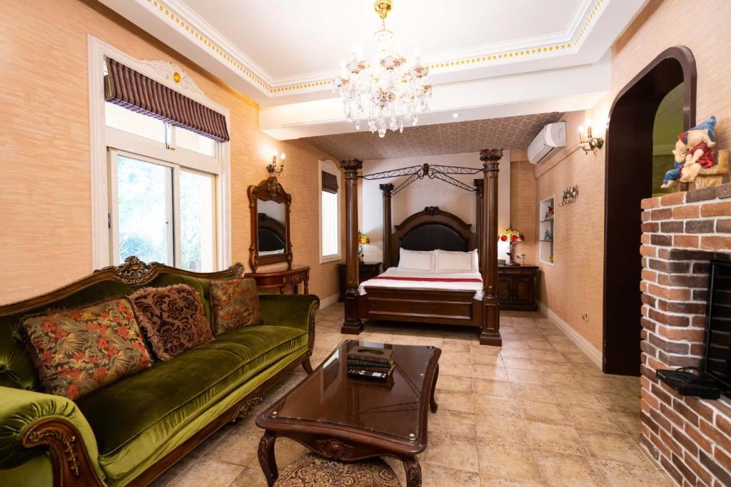 a living room with a green couch and a bed at Xin Yuan My Dream Castle in Dongshan