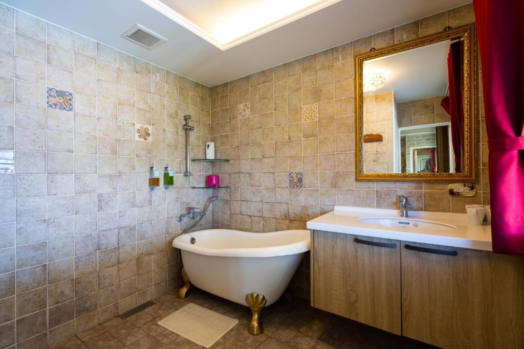 a bathroom with a tub and a sink and a mirror at Xin Yuan My Dream Castle in Dongshan