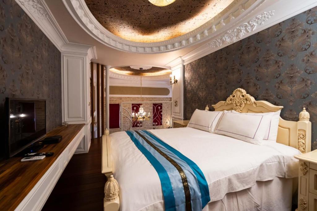 a bedroom with a large white bed and a ceiling at Xin Yuan My Dream Castle in Dongshan