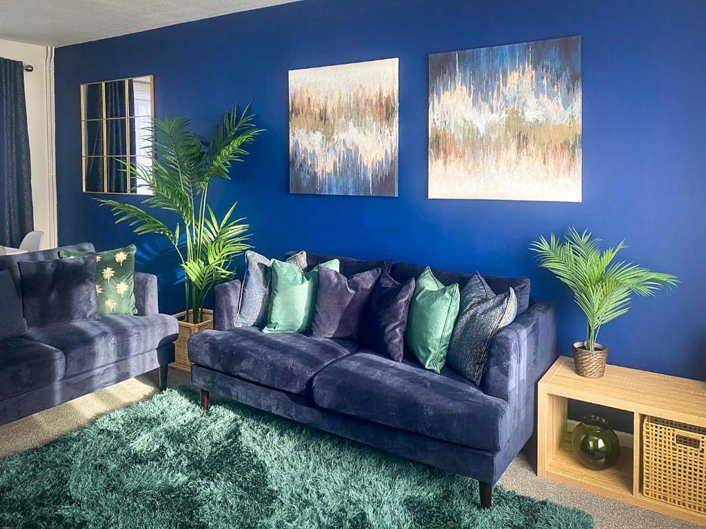 a living room with a purple couch and blue walls at Phoenix House - 2 Double Bedroom House - Business and Corporate Travellers in Luton