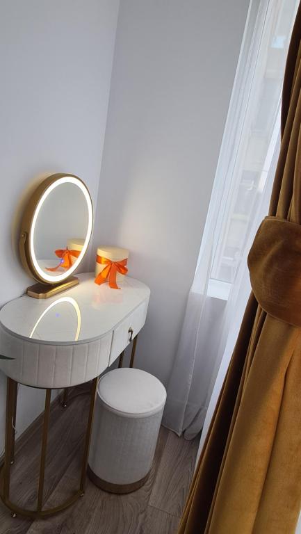 a dressing table with a mirror and a stool at Bianca's Place in Piteşti