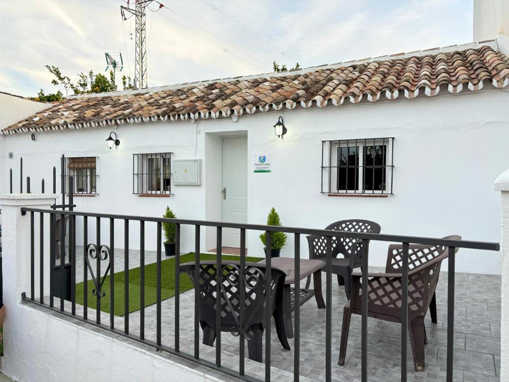 ein weißes Haus mit einem Tisch und Stühlen auf dem Balkon in der Unterkunft Casa Juan Harina in Setenil de las Bodegas