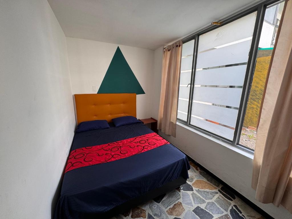 1 dormitorio con cama y ventana grande en Hostel Bogotá Normandia VIP, en Bogotá