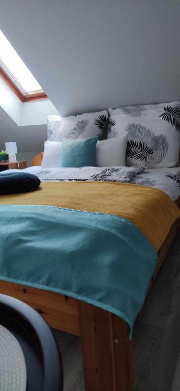 a bedroom with a large bed with blue sheets and pillows at Várfal apartman II in Eger