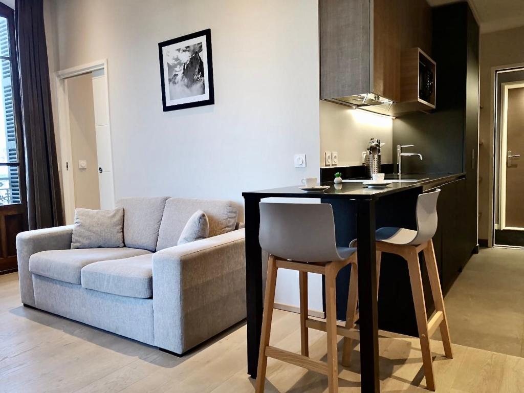 a living room with a couch and a kitchen with a table at Villa Saint Enogat in Aix-les-Bains