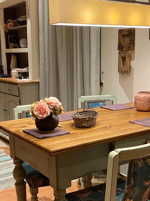 una mesa de madera con un jarrón con flores. en Villa Leśna, en Koszalin