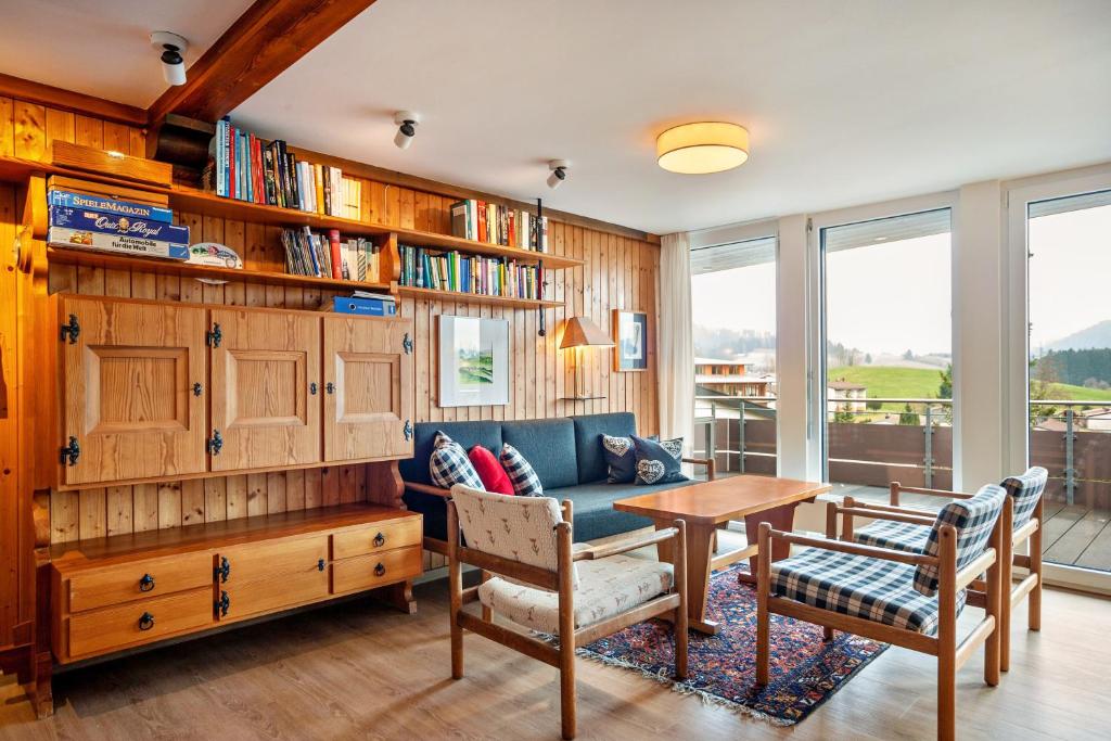 ein Wohnzimmer mit einem blauen Sofa und einem Tisch in der Unterkunft Ferienhaus Rommel in Stiefenhofen