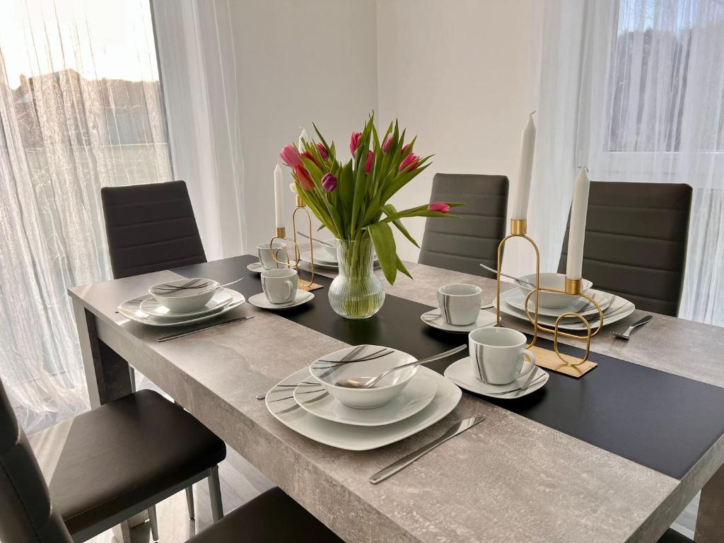 a dining room table with a vase of flowers on it at Apartment Weikersheim I in Weikersheim