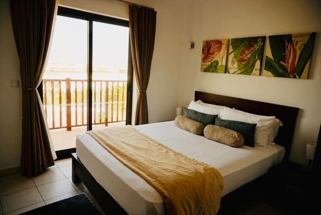 1 dormitorio con 1 cama grande y balcón en Residência Oceaníca Meliá Dunas Beach Resort & Spa, en Santa Maria