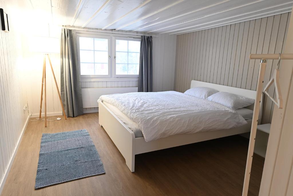 ein Schlafzimmer mit einem weißen Bett und einem Fenster in der Unterkunft Alter Zoll in Teufen