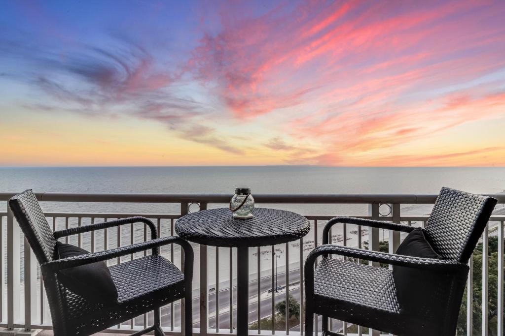 a table and two chairs on a balcony with the ocean at Gorgeous Oceanview 3BR Luxury Condo - Latitude in Gulfport