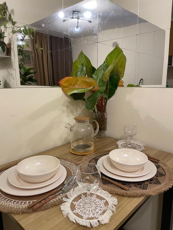 a table with plates and glasses on top of it at Cabin in Urban - Urban Deca Homes - Manila in Manila