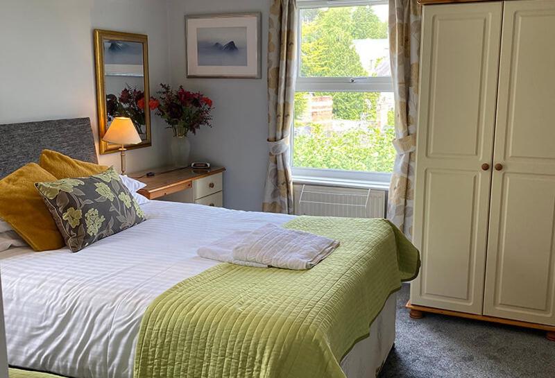 トーキーにあるBarramore Holiday Apartmentsの大きなベッドと窓のある寝室