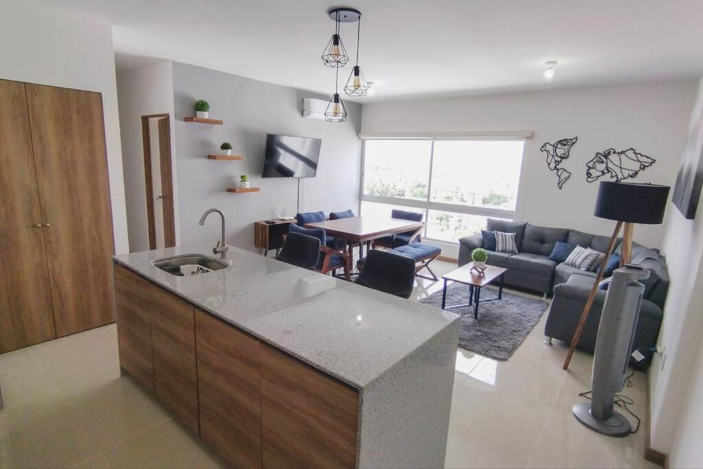 a kitchen and living room with a couch and a table at Escenia Comfort, 9th floor apt with awesome views! in Guadalajara