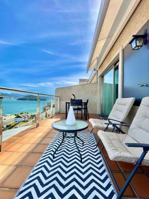 a patio with a table and chairs on a balcony at Casa Da Moura in Combarro